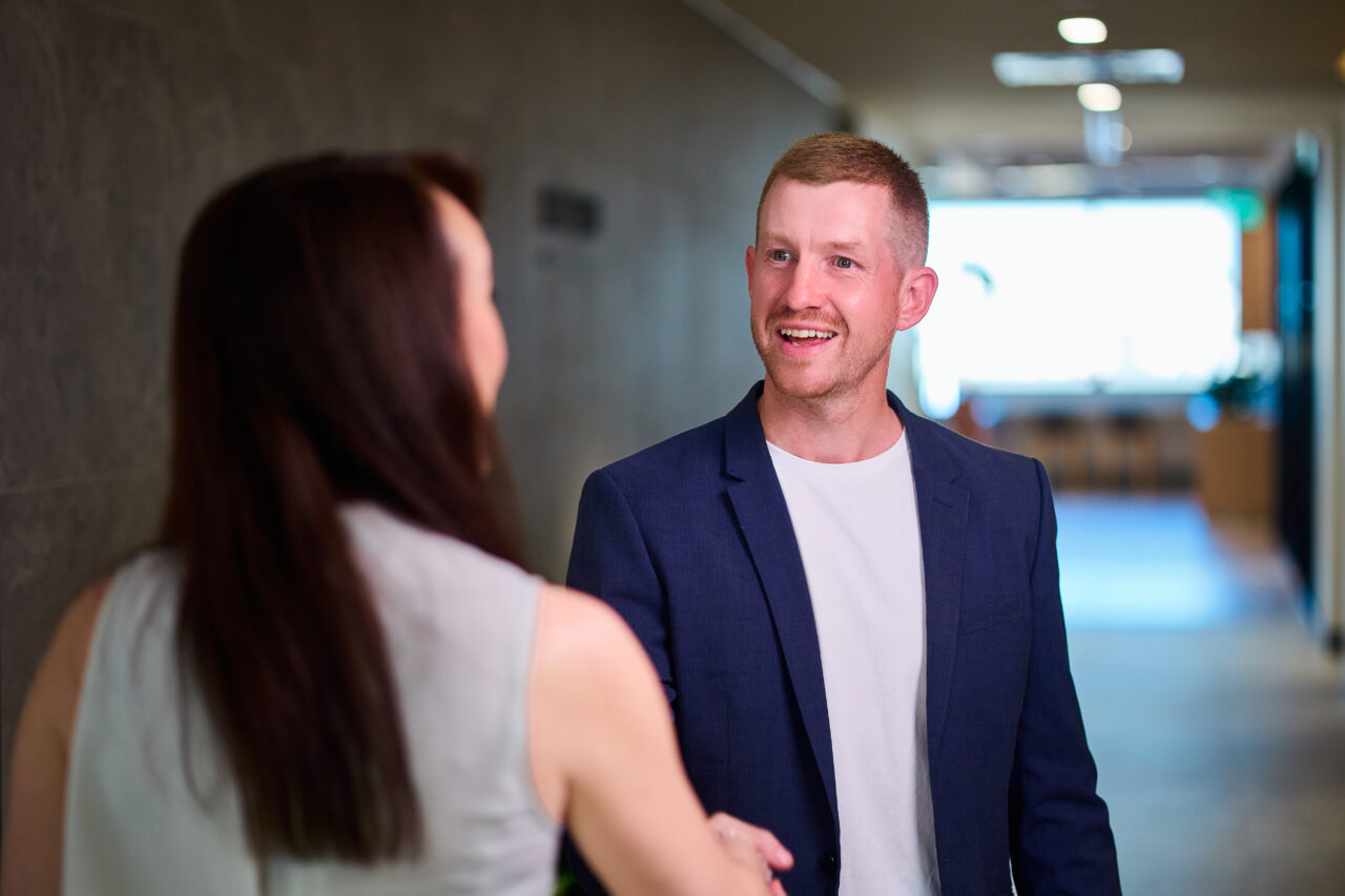 Personal injury solicitors greeting a client in the office corridor, reflecting Richardson & Lyons' commitment to client care.
